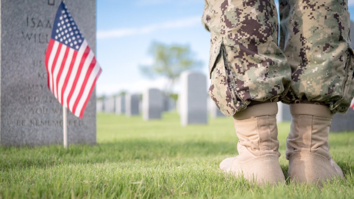 a soldier's legs and boots in front of a grave